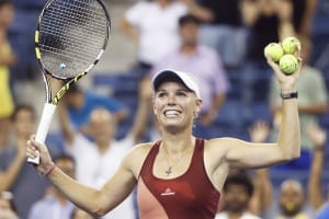 Caroline Wozniacki of Denmark hits autographed tennis balls into the crowd after defeating Sara Errani of Italy in their women's quarter-finals singles match at the 2014 U.S. Open tennis tournament in New York